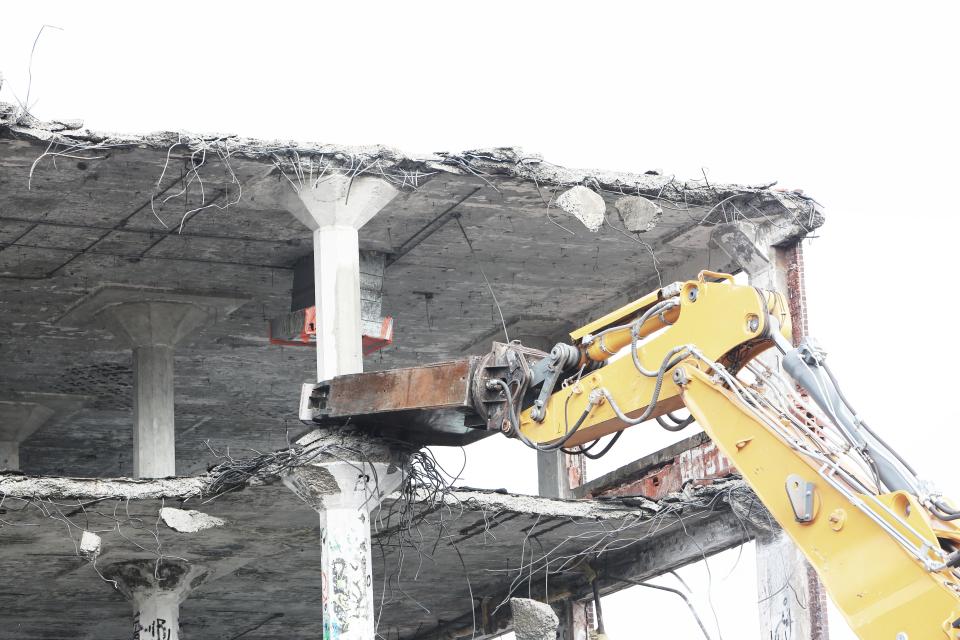 Abbruchbagger trägt eine Betonkonstruktion kontrolliert ab